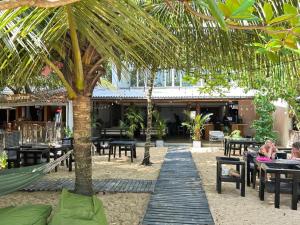 a resort with a hammock and tables and palm trees at FAM Hotel in Unawatuna +18 photos