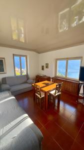una sala de estar con una mesa, sillas y un sofá en Finestra sul Lago Bellagio, en Civenna