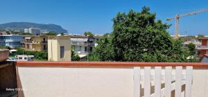 a white fence and a tree in a city at Brezza di Mare - Casa Casoni in Marcelli