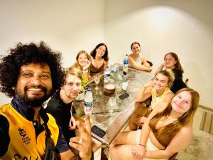 a group of people sitting around a table at Coastal Cloud Surf - Walk To Dewata Beach in Unawatuna