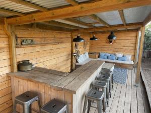 an outdoor kitchen with stools in a wooden cabin at La chambre de Laura in Castelnau-le-Lez