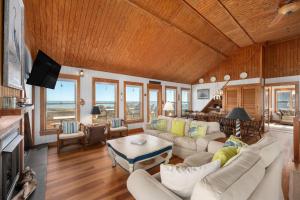 a living room with white furniture and a wooden ceiling at D124- Gillis in Sanderling