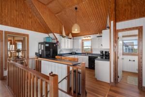 a kitchen with white cabinets and a wooden ceiling at D124- Gillis in Sanderling