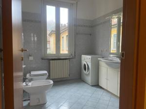 a bathroom with a toilet sink and a washing machine at Fior Di Sambuco in Broni
