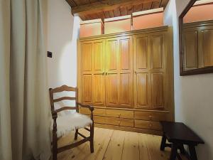 a room with a chair and a wooden cabinet at AC Apartaments Tarter Chalet in El Tarter