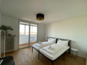 Un dormitorio con dos camas y una gran ventana. en LIBORIA I Über den Dächern Augsburgs, en Augsburg