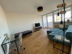 Una sala de estar con un sofá y un televisor. en LIBORIA I Über den Dächern Augsburgs, en Augsburg