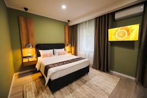 克拉约瓦Sawei Urban Hotel的卧室设有一张位于绿色墙壁上的床铺