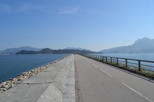 een lange pier strekt zich uit in het water bij YHA Bradbury Jockey Club Youth Hostel in Hong Kong