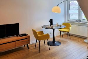 ボルクムにあるHaus Polarsternのテーブルと椅子とテレビのあるリビングルーム