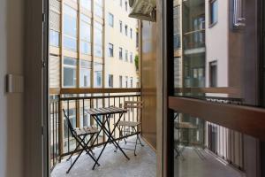 a balcony with a table and chairs and a window at YLS Luxury Suites 2 in Milan