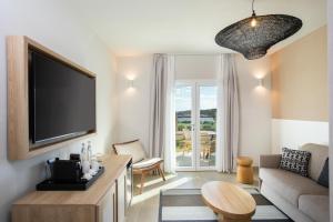 a living room with a flat screen tv on a wall at Mangia's Sardinia Resort in Santa Teresa Gallura