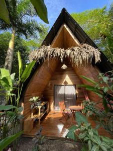 een klein houten huis met een tafel en een stoel bij Buena Onda Bungalows in Santa Teresa Beach