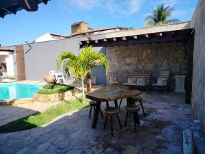 a patio with a table next to a pool at Casa confortável c piscina, lazer e espaço gourmet in Barra de São Miguel