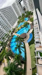 an aerial view of a building with pools and palm trees at Shell Residence MOA Pasay by Kathy in Manila