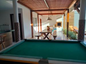a pool table in the middle of a living room at Casa confortável c piscina, lazer e espaço gourmet in Barra de São Miguel