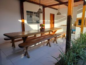 a wooden table and benches on a patio at Casa confortável c piscina, lazer e espaço gourmet in Barra de São Miguel