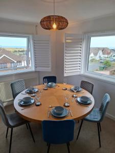 a dining room with a wooden table and chairs at 4 Bedroom House in Saltdean, Brighton in Brighton & Hove