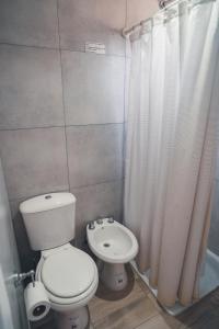 a bathroom with a toilet and a shower curtain at Check and home - Chapa II - 4 huéspedes con patio y parrilla in Chapadmalal +4 photos