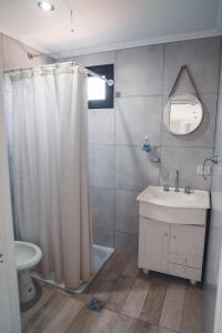 a bathroom with a shower curtain and a sink at Check and home - Chapa II - 4 huéspedes con patio y parrilla in Chapadmalal