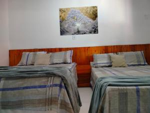 two beds sitting next to each other in a room at Casa confortável c piscina, lazer e espaço gourmet in Barra de São Miguel +46 photos