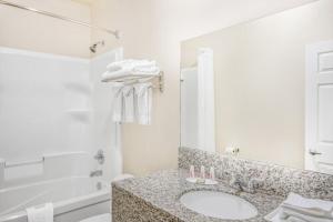 a white bathroom with a sink and a tub at High Point Inn & Suites Peace River in Peace River +25 photos