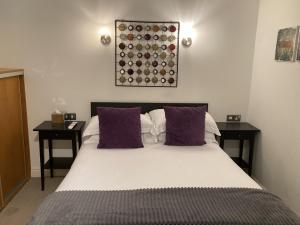 Un dormitorio con una cama grande con almohadas moradas. en NELL GWYNN HOUSE - Hotel Style POD Room 62, en Londres