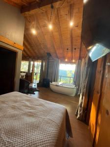a bedroom with a bed and a bath tub at Chalé Refúgio Panorâmico in Canela