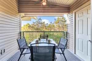 Un patio con una mesa y sillas en un balcón. en Peaceful 2BR Condo by Golf Course Pools, en Branson