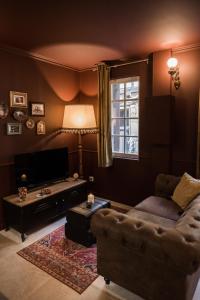 een woonkamer met een bank en een tafel bij Le Garrison - l'univers des Peaky Blinders à Bergerac in Bergerac