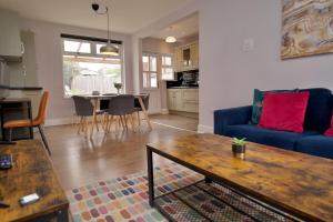 a living room with a blue couch and a table at Whitley House - Stylish 3 Bedroom Home near Coventry City Centre in Coventry