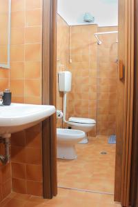 a bathroom with a toilet and a sink at Relax nel verde - WiFi & Parcheggio in Fanano +9 photos