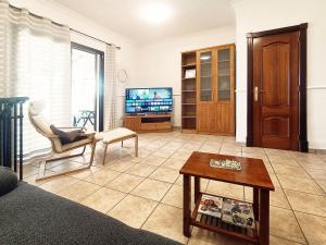 a living room with a couch and a tv at Los Azahares Apartment in Costa Del Silencio