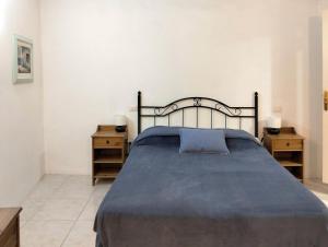 a bedroom with a bed with a blue blanket and two night stands at Los Azahares Apartment in Costa Del Silencio