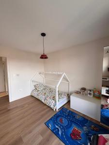 een slaapkamer met een wit bed en een blauw tapijt bij Échappée Alsacienne in Illzach