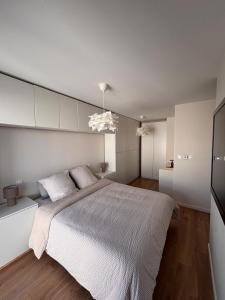 een slaapkamer met een groot bed met witte muren bij Échappée Alsacienne in Illzach