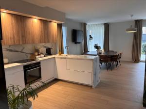 a kitchen with white cabinets and a dining room at Échappée Alsacienne in Illzach