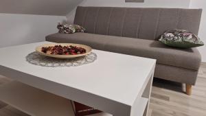 een witte salontafel met een fruitschaal erop bij Apartman Kovačić in Kutina
