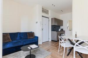 a living room with a blue couch and a table at YLS Luxury Suites 2 in Milan