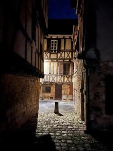 een steegje met een oud gebouw in een stad bij Le Garrison - l'univers des Peaky Blinders à Bergerac in Bergerac