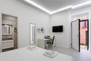 a white room with a bed and a desk at Isola nel Parco Villas & Rooms in La Maddalena