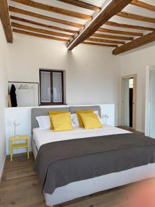 a bedroom with a large bed with yellow pillows at Sara Home in Guarene