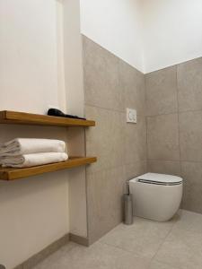 a bathroom with a white toilet and some towels at Sara Home in Guarene