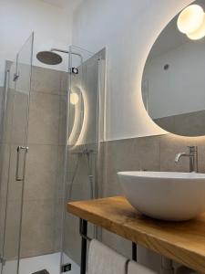 a bathroom with a sink and a glass shower at Sara Home in Guarene +29 photos