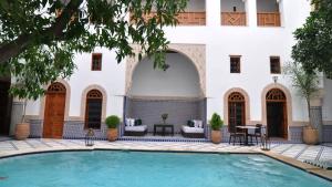 非斯里亚德沙巴酒店的建筑物前的游泳池