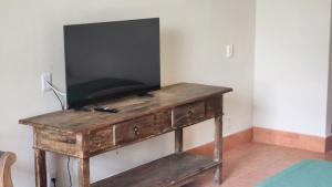 a wooden table with a television on top of it at Quinta das Águas Hotel in Itapira +4 photos