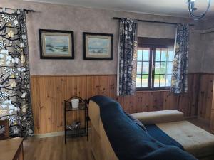 a living room with a couch and two windows at El Dúplex del Monumento in San Juan de Aznalfarache