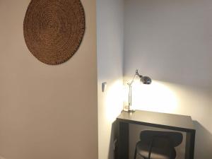 a desk with a chair and a lamp on a wall at Ritual do Mar - Suite com WC - Baleal & Peniche in Ferrel