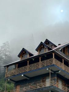 a house with a deck on top of it at Alpine suites in Nagar