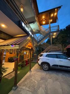 a white car parked in front of a house at Alpine suites in Nagar